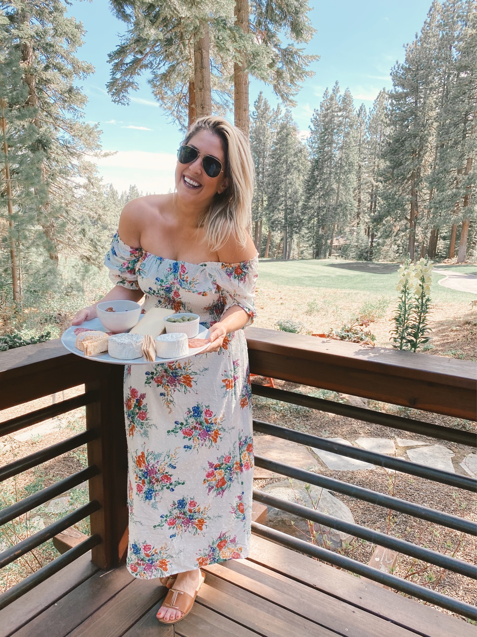 San Francisco fashion blogger KatWalkSF wearing the WAYF Smocked Midi Dress in Lake Tahoe holding a Cowgirl Creamery cheese board.