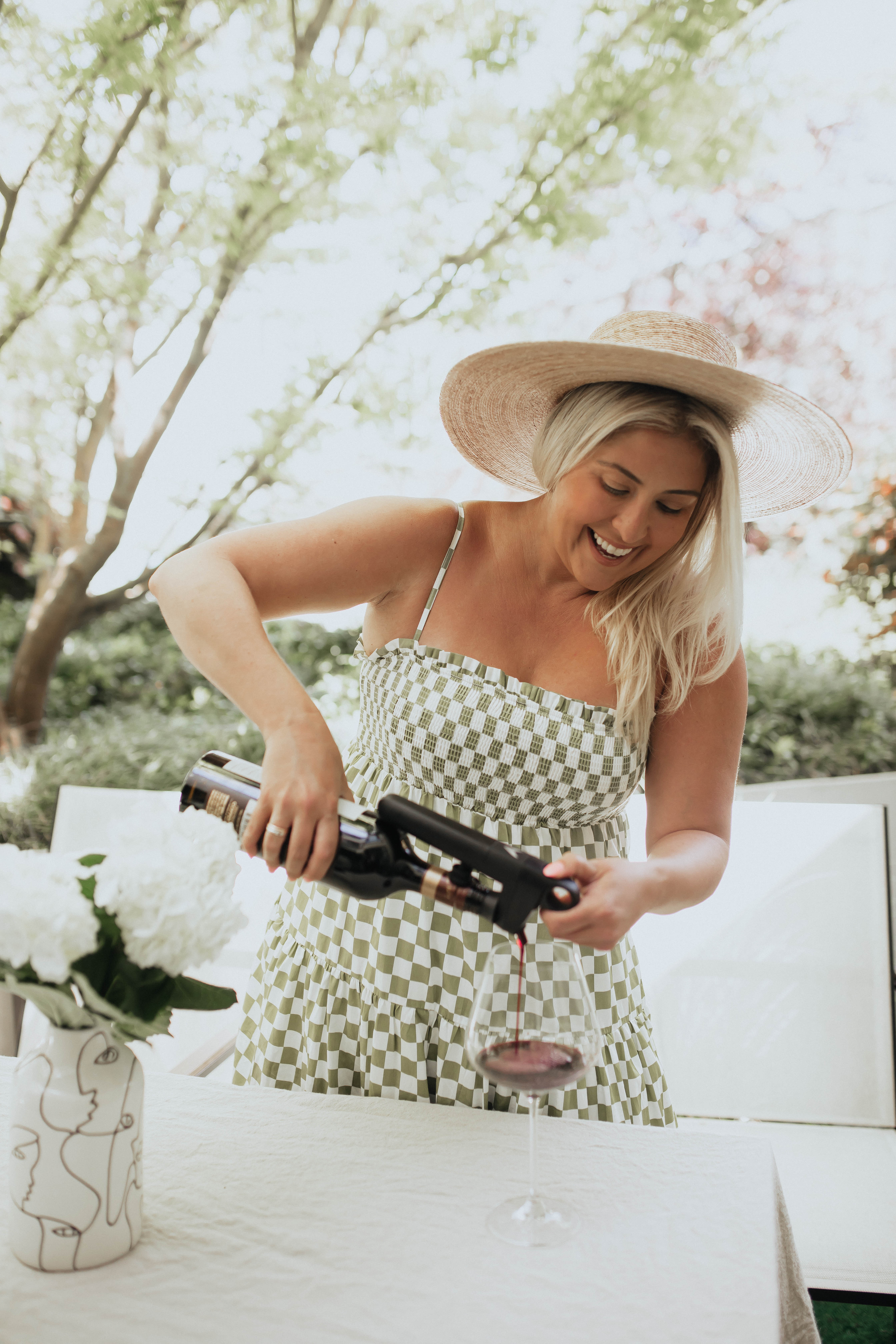 San Francisco fashion and lifestyle blogger KatWalkSF pours wine with the Coravin Pivot in her San Francisco patio.