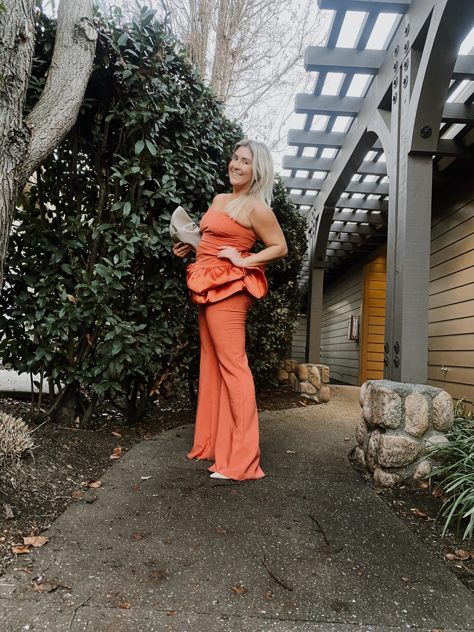 Kat Ensign wearing the ASOS LUXE Bandeau Tunic Top + Flare Pant Set at the Hotel Yountville and holding The Senreve Conetti Bag